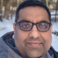 Rishi Dhawan close up with snow behind him.