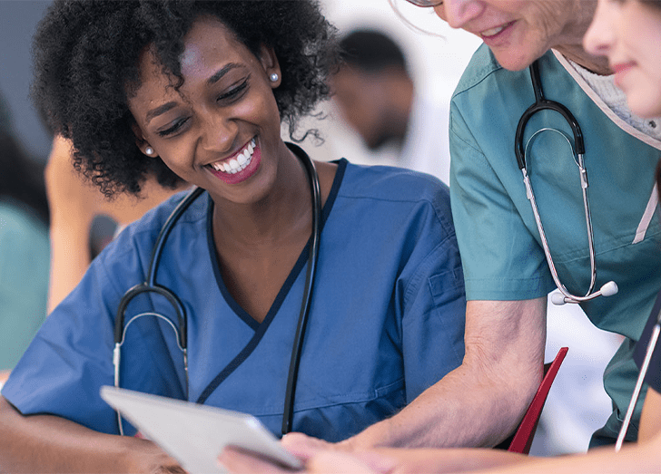 Senior female lecturer assists medical students during class.