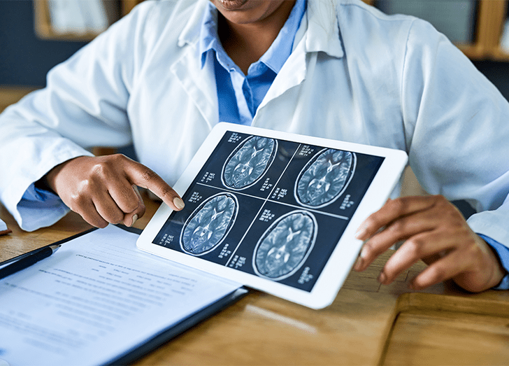 Shot of a doctor using a digital tablet to discuss a brain scan during a consultation in her office.
