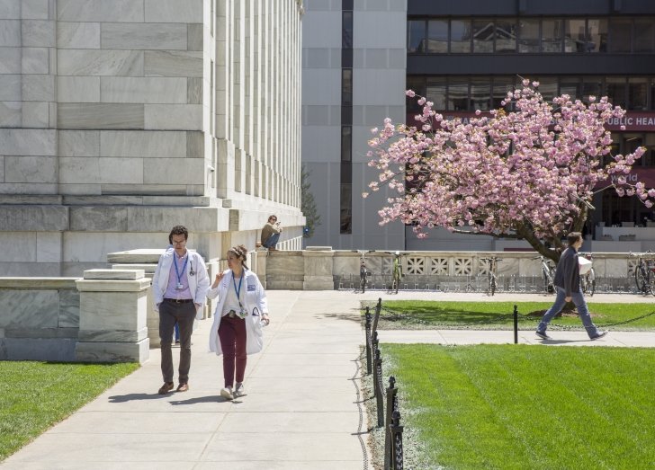 Two people walking on the HMS Quad.
