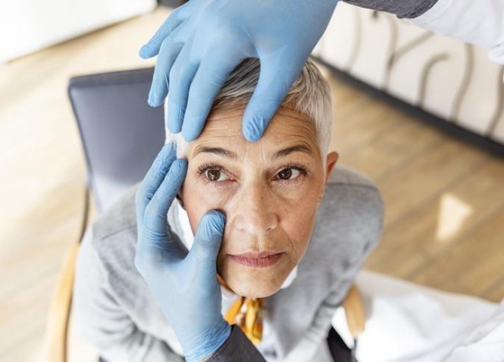 Doctor conducts eye exam on woman.