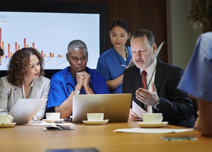 Businesspeople and health care providers in a meeting.