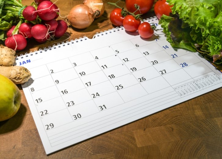 Calendar surrounded by fruits and vegetables.