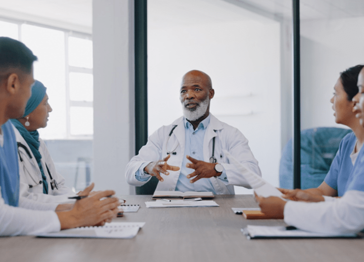 groups of physicians talks at a desk.