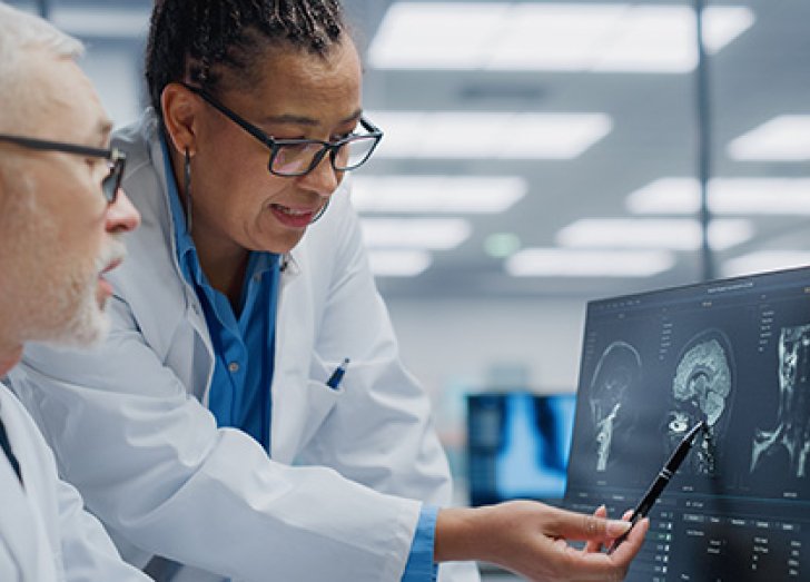 female and male doctor reviewing a brain scan.