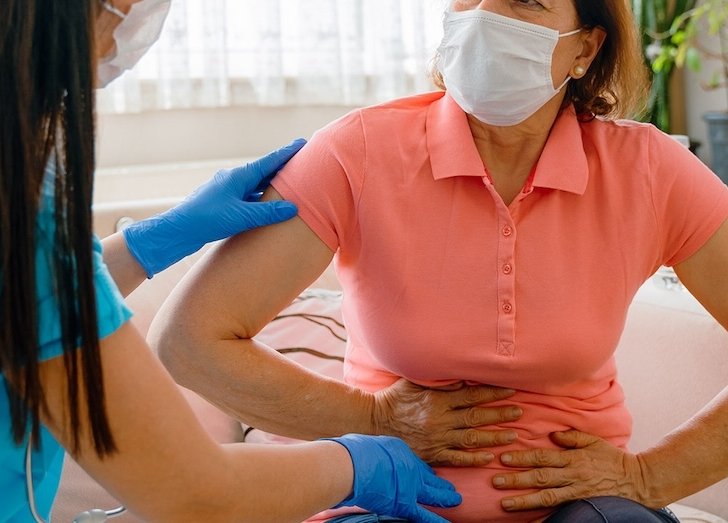 female doctor examining patients stomach.