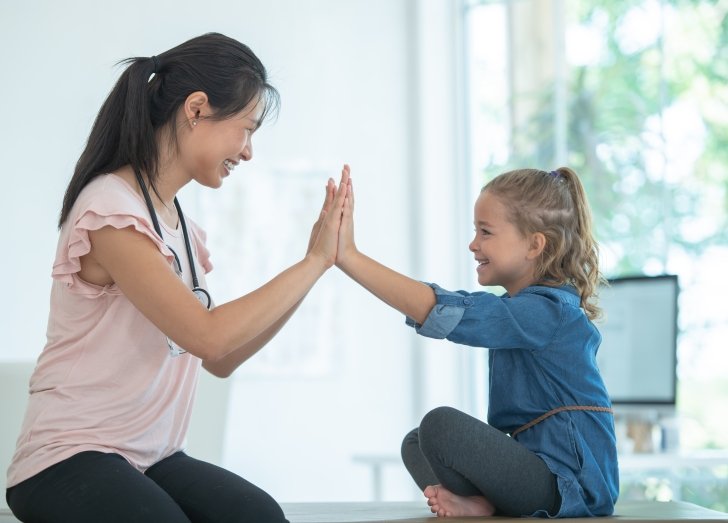 Female doctor working with young child on a stretching table