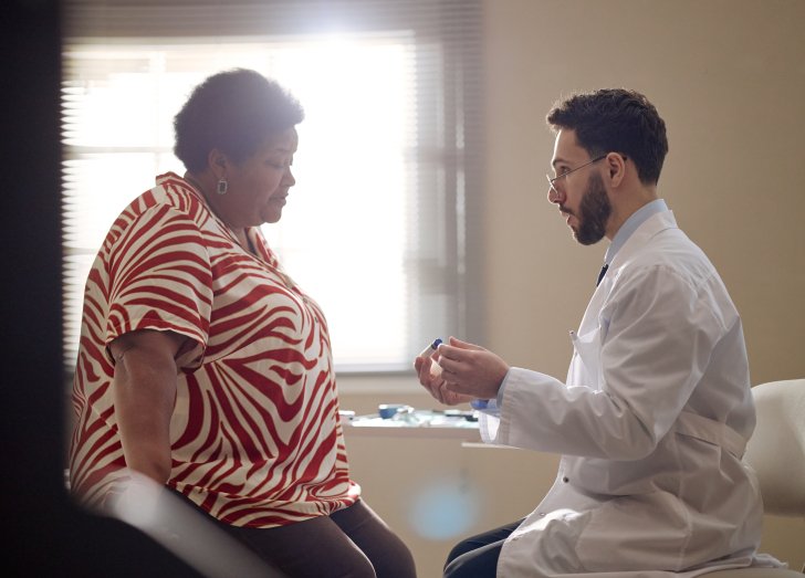 Black Middle Aged Woman Consulting Doctor during Medical Visit