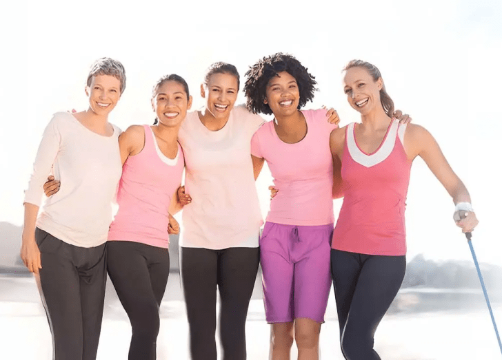 Women in a group standing and smiling.