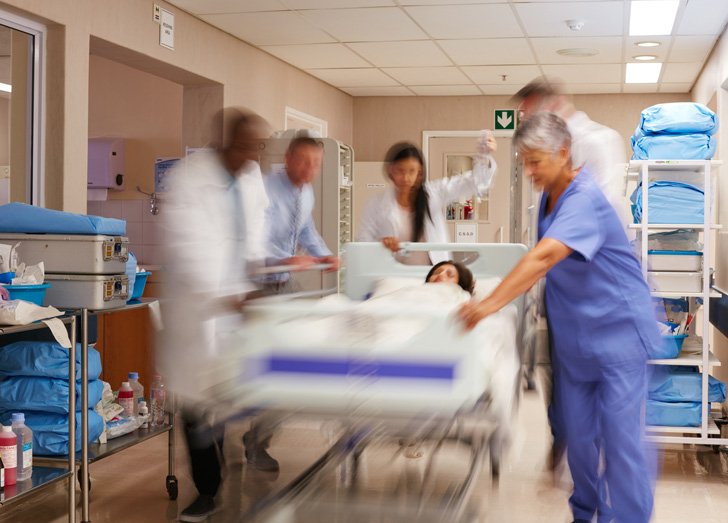 Emergency personnel rush in the hospital corridors with a patient.