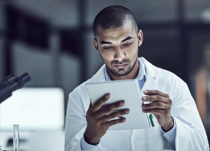Shot of a scientist recording his findings on a digital tablet.