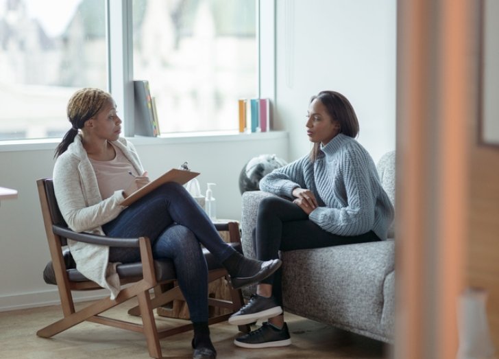 female psychologist sitting talking with a female patient.