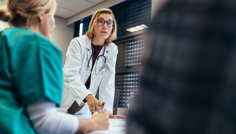 A doctor leading a discussion and communicating with fellow health care professionals.
