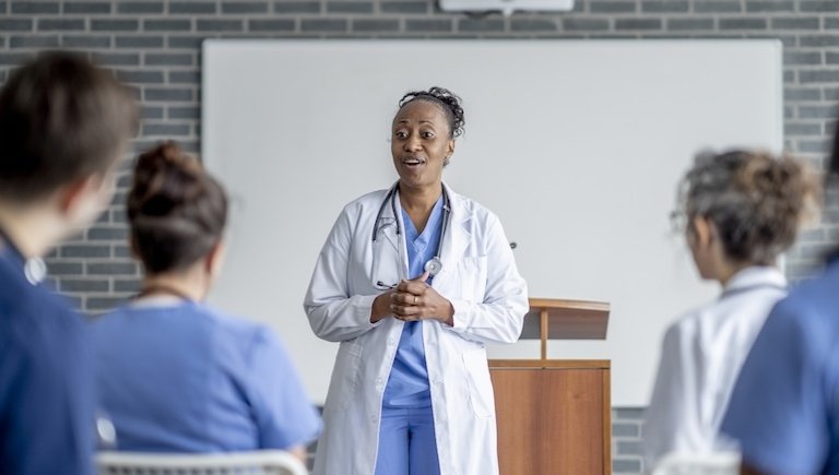 A clinician speaks to a classroom.