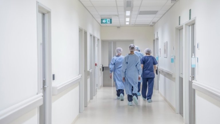 four doctors walking down the hospital wing.