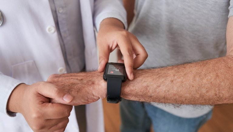 A doctor looks at a patient's watch. 