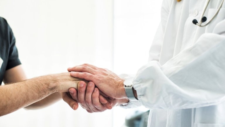 A doctor comforts a patient.