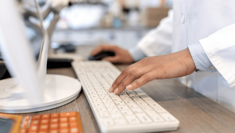 A doctor typing on a keyboard.