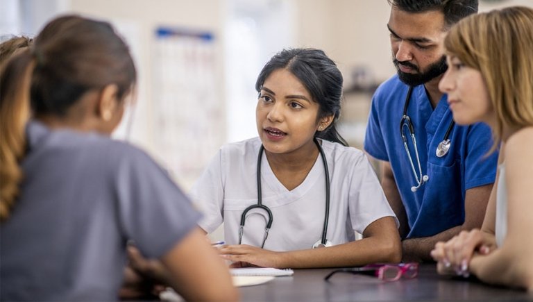 A health care professional speaking with team members.