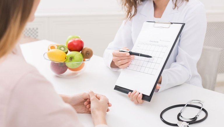 female nutritionist explaining a chart to a patient.