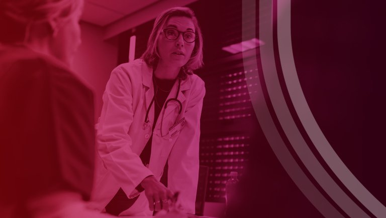 Medical Professional Leaning Over Conference Table