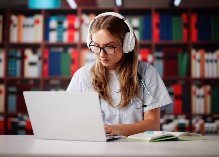 A girl studying in a library with headphones and a laptop.