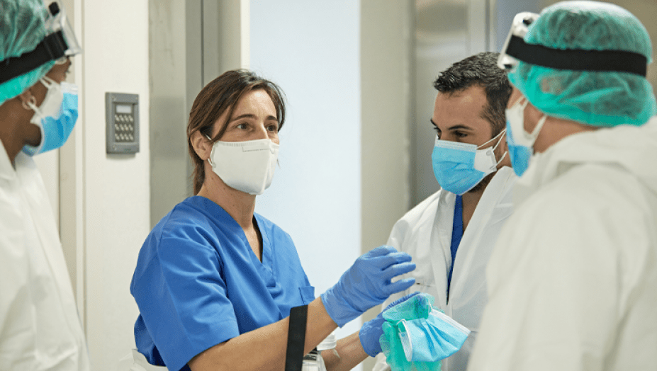 Health care workers talking with masks.