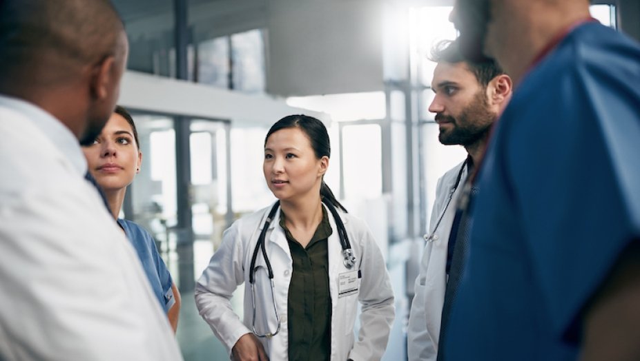 small group of doctors conversing in a circle.