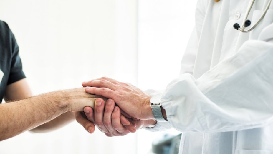 A doctor comforts a patient.