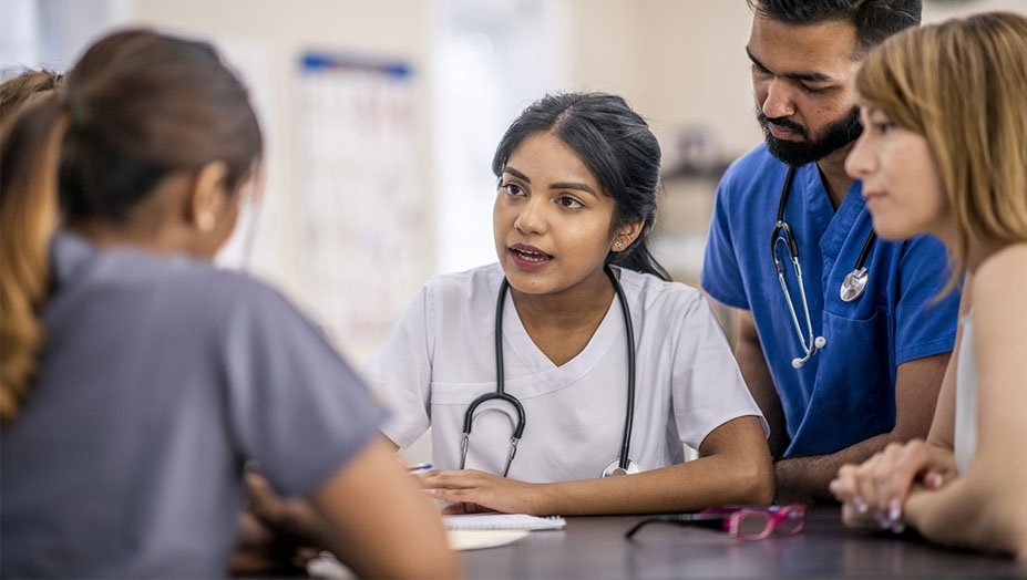 A health care professional speaking with team members.