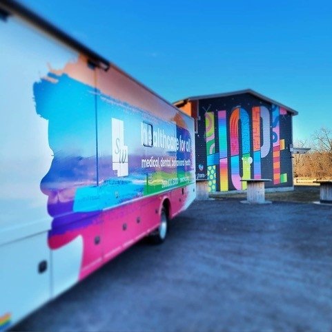 Mobile medical vehicle parked in front of brightly colored hope mural.