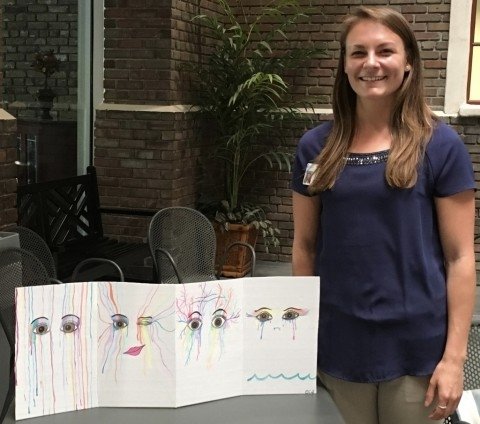 Girl standing with painting of eyes