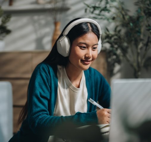 Student wearing headphones studying on her computer. 