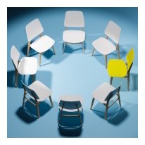 White chairs in a circle on blue background with one yellow chair